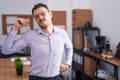Young hispanic man at the office stretching back, tired and relaxed, sleepy and yawning for early morning Royalty Free Stock Photo