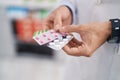 Young hispanic man pharmacist smiling confident holding pills tablets at pharmacy Royalty Free Stock Photo