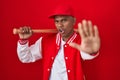 Young hispanic man playing baseball holding bat doing stop gesture with hands palms, angry and frustration expression Royalty Free Stock Photo