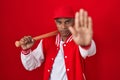 Young hispanic man playing baseball holding bat doing stop sing with palm of the hand Royalty Free Stock Photo