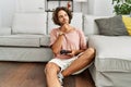 Young hispanic man playing video game holding controller at home serious face thinking about question with hand on chin, Royalty Free Stock Photo