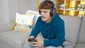 Young hispanic man playing video game with serious face at home Royalty Free Stock Photo