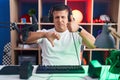 Young hispanic man playing video games doing thumbs up and down, disagreement and agreement expression Royalty Free Stock Photo