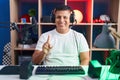 Young hispanic man playing video games showing and pointing up with finger number one while smiling confident and happy Royalty Free Stock Photo