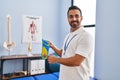 Young hispanic man podiatrist holding insole at podiatry center