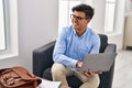 Young hispanic man psychologist using laptop at psychology clinic