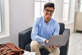 Young hispanic man psychologist using laptop at psychology clinic