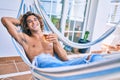 Young hispanic man relaxed drinking beer lying on the hammock at terrace Royalty Free Stock Photo