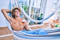 Young hispanic man relaxed drinking beer lying on the hammock at terrace Royalty Free Stock Photo