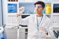 Young hispanic man scientist holding pill with hand at street Royalty Free Stock Photo