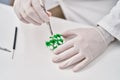 Young hispanic man scientist holding pill with tweezer at laboratory Royalty Free Stock Photo