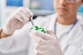 Young hispanic man scientist holding pill with tweezer at laboratory Royalty Free Stock Photo