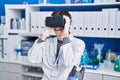 Young hispanic man scientist using virtual reality glasses at laboratory Royalty Free Stock Photo