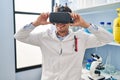 Young hispanic man scientist using virtual reality glasses at laboratory Royalty Free Stock Photo