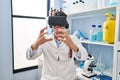 Young hispanic man scientist using virtual reality glasses at laboratory Royalty Free Stock Photo