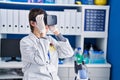 Young hispanic man scientist using virtual reality glasses at laboratory Royalty Free Stock Photo