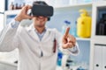 Young hispanic man scientist using virtual reality glasses at laboratory Royalty Free Stock Photo