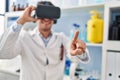 Young hispanic man scientist using virtual reality glasses at laboratory Royalty Free Stock Photo
