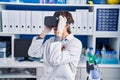 Young hispanic man scientist using virtual reality glasses at laboratory Royalty Free Stock Photo
