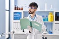 Young hispanic man scientist writing on notebook working at laboratory Royalty Free Stock Photo