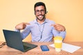 Young hispanic man sitting at the desk wearing operator headset at the call center office looking confident with smile on face, Royalty Free Stock Photo