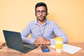 Young hispanic man sitting at the desk wearing operator headset at the call center office with serious expression on face Royalty Free Stock Photo