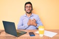 Young hispanic man sitting at the desk wearing operator headset at the call center office smiling with hands on chest with closed Royalty Free Stock Photo