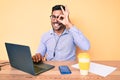 Young hispanic man sitting at the desk wearing operator headset at the call center office smiling happy doing ok sign with hand on Royalty Free Stock Photo