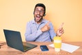 Young hispanic man sitting at the desk wearing operator headset at the call center office smiling and looking at the camera Royalty Free Stock Photo