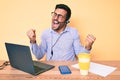 Young hispanic man sitting at the desk wearing operator headset at the call center office very happy and excited doing winner Royalty Free Stock Photo