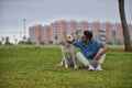 Young Hispanic man, sitting on the grass hugging his dog and looking at him very tenderly. Concept, dogs, pets, animals, friends Royalty Free Stock Photo