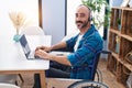 Young hispanic man sitting on wheelchair teleworking at home Royalty Free Stock Photo