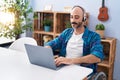 Young hispanic man sitting on wheelchair teleworking at home Royalty Free Stock Photo