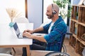 Young hispanic man sitting on wheelchair teleworking at home Royalty Free Stock Photo