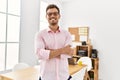 Young hispanic man smiling confident with arms crossed gesture at office Royalty Free Stock Photo