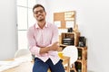 Young hispanic man smiling confident with arms crossed gesture at office Royalty Free Stock Photo