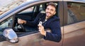 Young hispanic man smiling confident holding key of new car at street Royalty Free Stock Photo