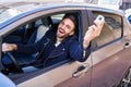 Young hispanic man smiling confident holding key of new car at street Royalty Free Stock Photo