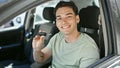 Young hispanic man smiling confident holding key of new car at street Royalty Free Stock Photo