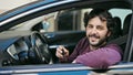 Young hispanic man smiling confident holding key of new car at street Royalty Free Stock Photo