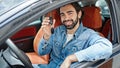 Young hispanic man smiling confident holding key of new car at street Royalty Free Stock Photo