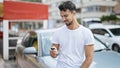 Young hispanic man smiling confident holding key of new car at street Royalty Free Stock Photo