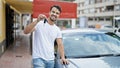 Young hispanic man smiling confident holding key of new car at street Royalty Free Stock Photo