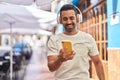 Young hispanic man smiling confident listening to music and dancing at street Royalty Free Stock Photo