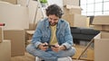 Young hispanic man smiling confident playing video game at new home Royalty Free Stock Photo