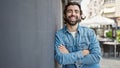 Young hispanic man smiling confident standing with arms crossed gesture at street Royalty Free Stock Photo