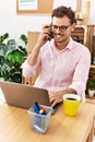 Young hispanic man smiling confident talking on the smartphone at office Royalty Free Stock Photo