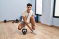 Young hispanic man smiling confident tying shoes at sport center Royalty Free Stock Photo