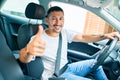 Young hispanic man smiling happy doing ok sign driving car Royalty Free Stock Photo