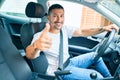 Young hispanic man smiling happy doing ok sign driving car Royalty Free Stock Photo
